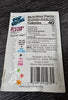 A close-up of the back of a Pop Rocks Mystery Flavor Popping Candy package, showing nutrition facts, ingredients, and a barcode, placed on a dark wood surface.